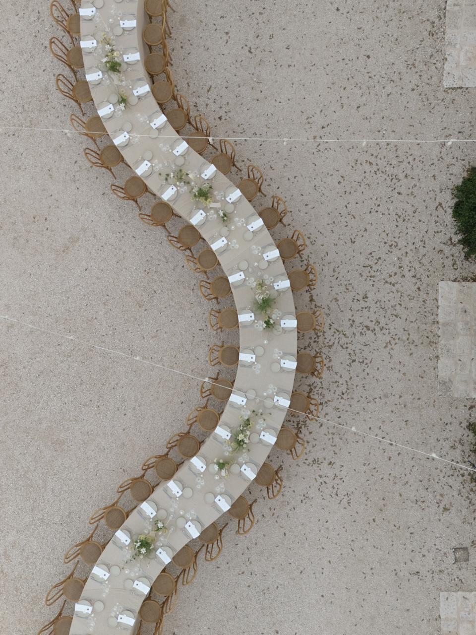 Aerial view of a catered wedding dinner table outside Masseria Pistola