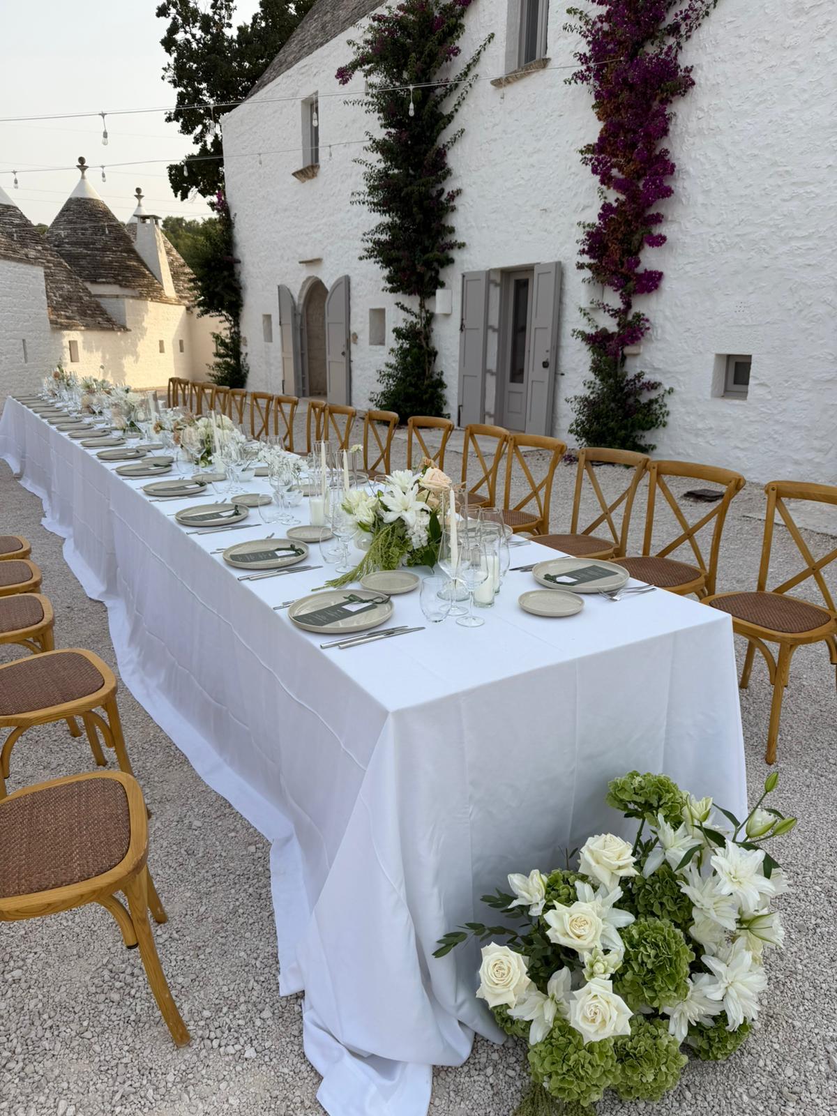 White flowers and a long wedding table outside the Masseria