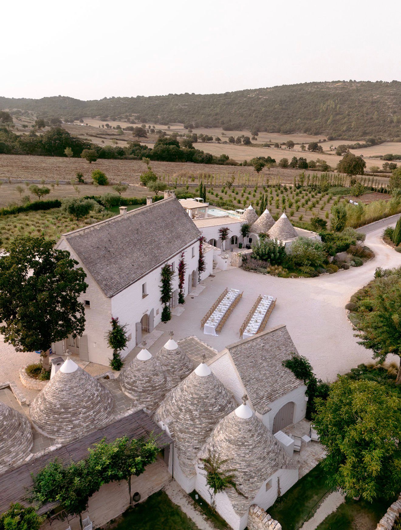 Aerial view of wedding tables beside the Masseria and trulli
