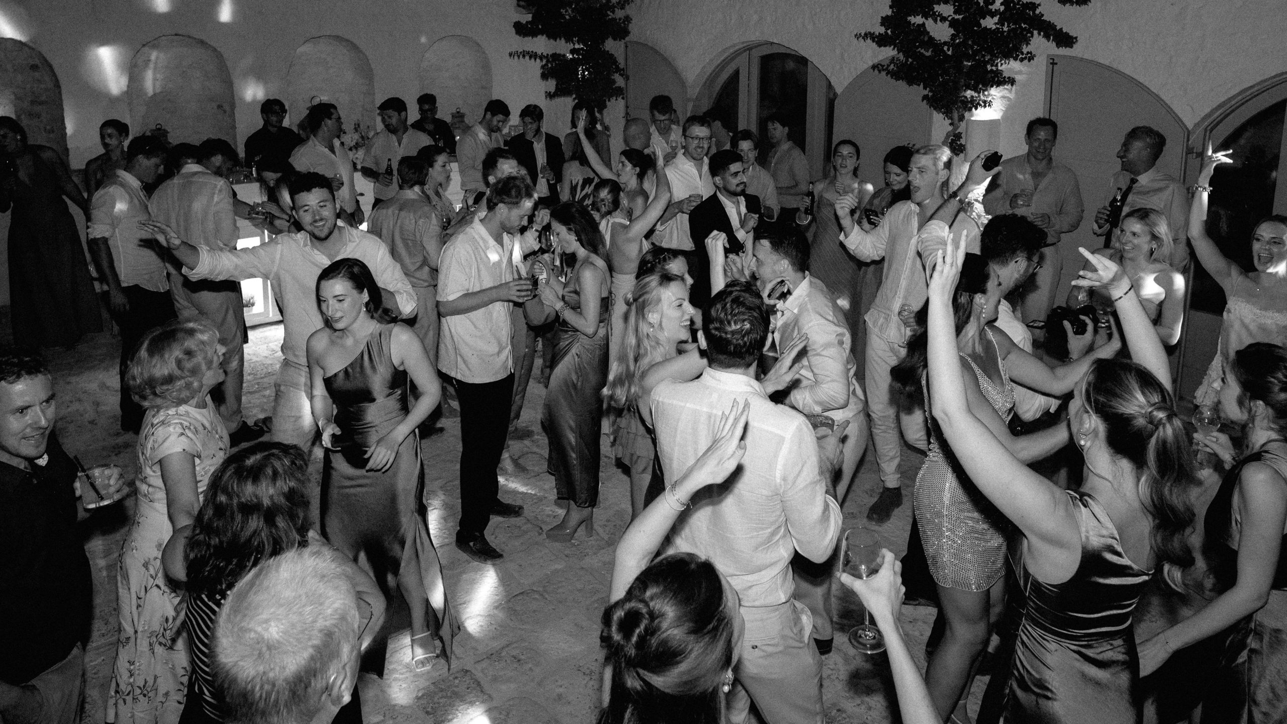Wedding guests dancing together in the courtyard